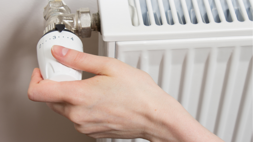 Kobieta regulująca moc kaloryfera