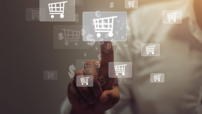 Ręka wskazująca wirtualne koszyki sklepowe