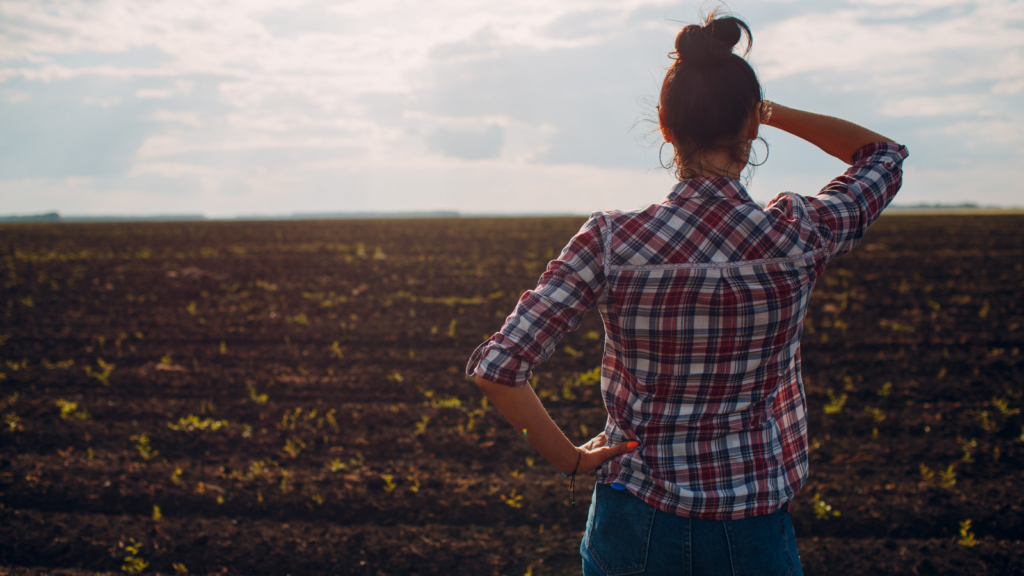 Kobieta, odwrócona tyłem, patrząca na pole