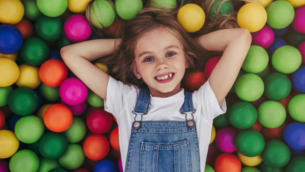 Dziewczynka leżąca na kulkach do zabawy